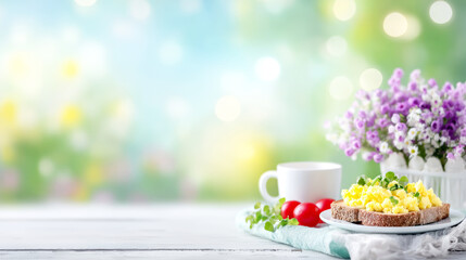 Healthy breakfast with scrambled eggs on whole grain toast, fresh tomatoes and a hot drink on a spring morning