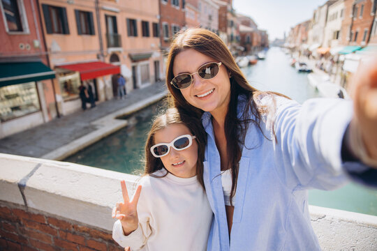 Mother and daughter enjoying Venice travel taking selfie