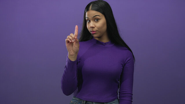 Young latin woman standing centered counts her fingers from one to three in a purple studio; order sequence focus progression.