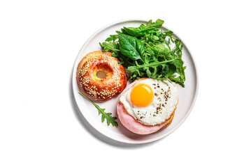Healthy breakfast. Bagel sandwich with fried egg, ham and greens