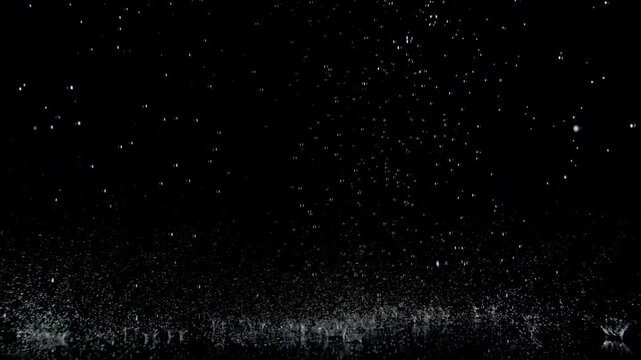 Super Slow Motion Shot of Real Raindrops Falling on a Surface, Isolated on Black, at 1000fps