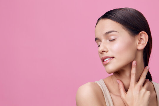 Beautiful young woman with flawless skin, closed eyes, and a serene smile on a pink background, embodying the concept of natural beauty and skincare