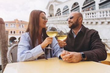 Couple toasting wine at cafe in Venice, Italy