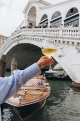 Woman holding white wine in Venice, Italy
