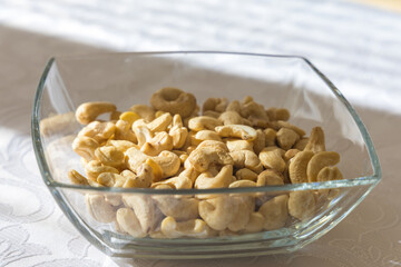 Detailed shot of a glass bowl filled with cashew nuts