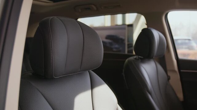 Close up detail shot of luxury car interior with focus on leather seats with comfortable headrests on display in dealership showroom, copy space