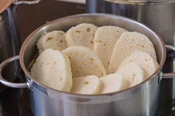 Detailed shot of a stainless steel pot filled with slices of traditional steamed dumpling