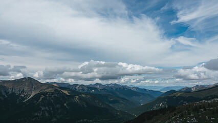 Mountain landscape with clouds and blue sky, scenic view of nature and mountain range.