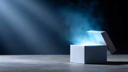 Open white gift box emitting glowing blue light and smoke on dark background with spotlight beam