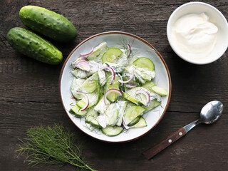Overhead view of easy creamy Greek yogurt cucumber salad made with cucumbers, lemon , red onions and fresh dill.
