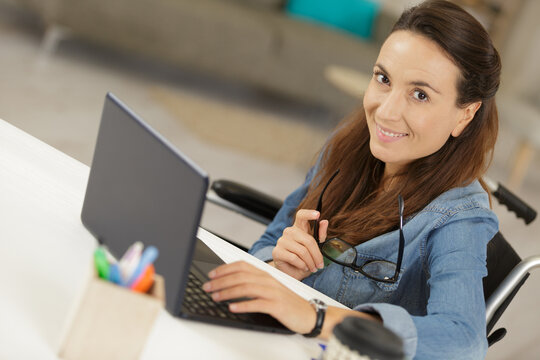 woman sitting on wheelchair using her laptop