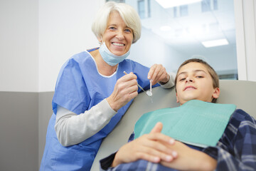 Obraz premium senior female dentist with a kid patient