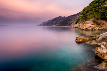 Croatia, Dalmatia, the Adriatic coast at sunrise, with the Biokovo Mountains and forests in the background. The village of Brela is a summer resort on the Makarska Riviera.