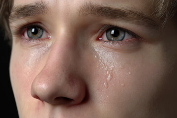Fototapeta premium Emotional close-up of a young person with tears in their eyes expressing intense feelings