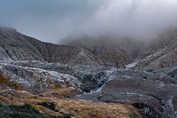 Deep ravines and folds of the acid-scarred, mist-covered mountain slope at Poás Volcano, Costa...