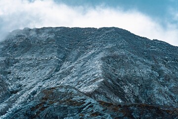 Massive, steep crater wall showing extreme blue-gray and white acid erosion at Po&aacute;s Volcano, Costa Rica.