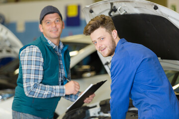 Naklejka premium portrait of a mechanics taking notes and smiling