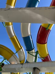 Colorful water slides against a clear blue sky viewed from underneath
