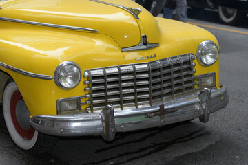 Fototapeta premium front of a yellow vintage vehicle at a film set on Bay St, Toronto