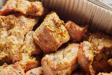 Close-up of grilled shashlik kebab pieces in a foil tray