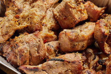 Close-up of grilled shashlik kebab pieces in a foil tray