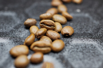 Close-up of a group of roasted coffee beans on a black baking tray background