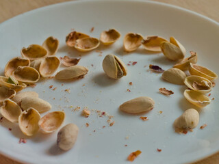 Perspective Shot of Eaten Pistachio Shells Left on White Plate