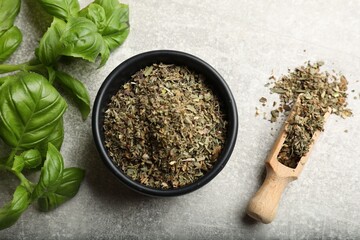 Fresh and dry basil leaves on light grey table, flat lay