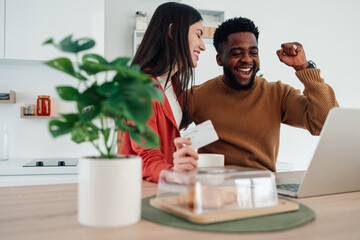Happy interracial couple online shopping with credit card
