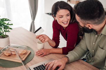 Happy couple enjoying online shopping with credit card