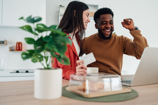 Happy interracial couple online shopping with credit card