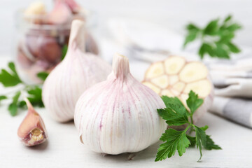 Garlic and parsley on white table, closeup