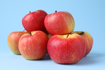 Ripe red apples on light blue background, closeup