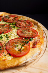pizza napolitana con tomate y queso en fondo negro