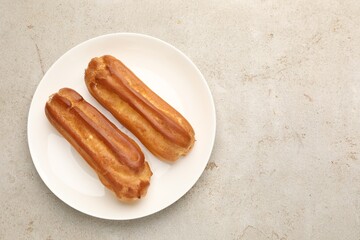 Tasty eclairs on light table, top view. Space for text