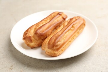 Fresh tasty eclairs on light table, closeup