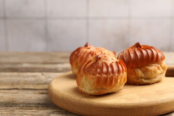 Tasty profiteroles on wooden table, closeup. Space for text