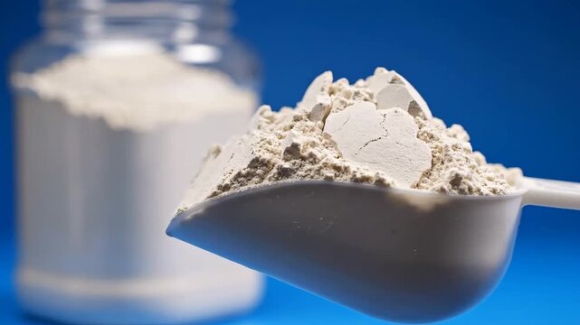 Protein powder scoop and jar on a blue background for fitness and health.