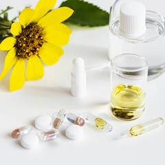 Collection of supplements and essential oils with a vibrant mood near a sunflower

