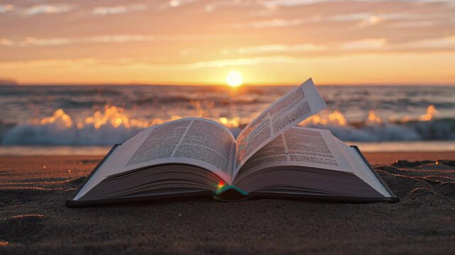 Background video of an open book lying on the sand by the ocean. The breeze turns its pages. The sun is setting, casting a warm glow on the book. The scene is peaceful and serene.