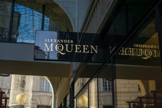 Vienna, Austria, Europe - Nov 08, 2025: alexander mcqueen store sign with gold lettering reflecting on a glass facade in the goldenes quartiervienna