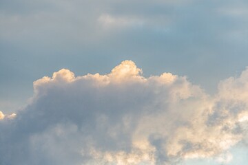 Wide, tranquil skyscape with scattered fluffy white clouds Dawndusk soft lighting with pink, orange hues and cloud illumination Sky transitioning to light gray at bottom, contrasting textured clou