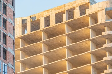 Partially built concrete structure with reinforcing bars and beams, under construction or...