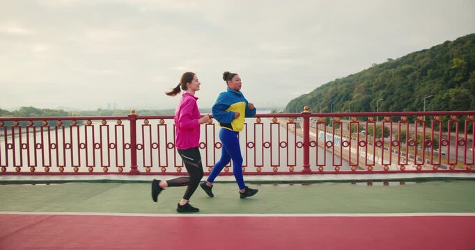 Runners jog across pedestrian bridge and discuss weekend plans