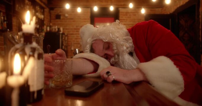 Drunk santa claus sleeping and drinking at the bar counter