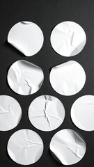 Vertical shot of white, wrinkled circle stickers on a black surface