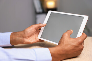 African-american man using tablet at wooden table indoors, closeup