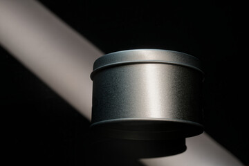Black metallic round tin jar mockup with dramatic light beam. Blank packaging container for men grooming wax, beard balm, or cosmetic cream. Photo