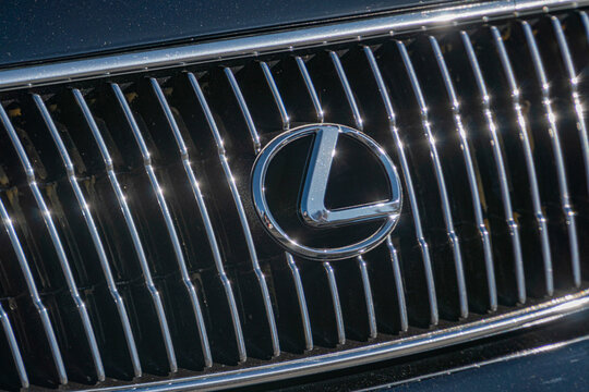 Close-up image of a polished Lexus front grille with reflective metallic logo - Kyiv, Ukraine - September 21, 2025