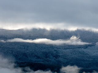 Snowy Mountain Range Above Forest Clouds in BC, Canada — Misty Winter Morning Panorama View